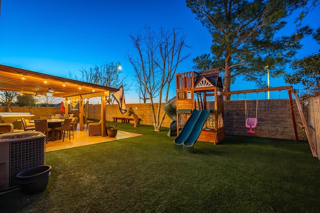 view of jungle gym with a lawn, a patio, central AC, and a fenced backyard