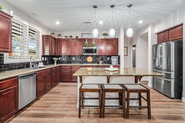 kitchen featuring decorative backsplash, light wood-style flooring, appliances with stainless steel finishes, and a sink