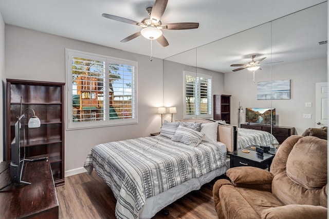 bedroom with baseboards, wood finished floors, and a ceiling fan