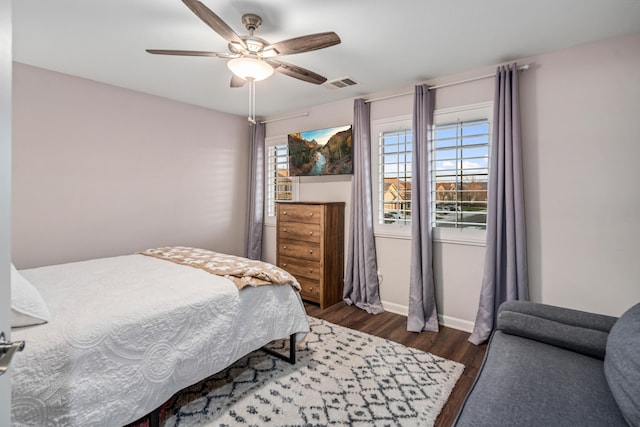 bedroom featuring visible vents, baseboards, ceiling fan, and dark wood-style flooring