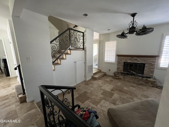 6001 Brougham St, Lancaster, CA 93536 - living area featuring stone finish flooring, plenty of natural light, a chandelier, and a glass covered fireplace