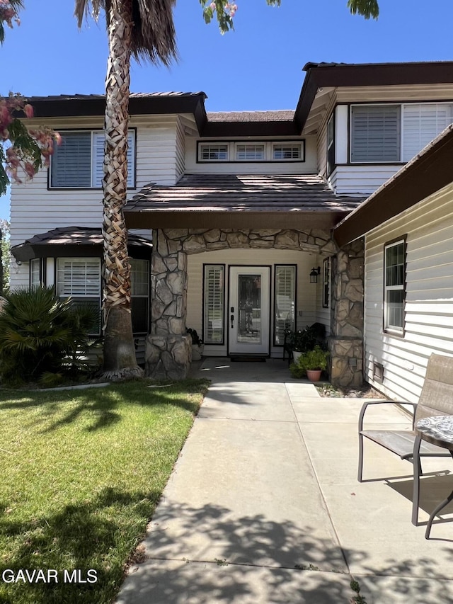 6001 Brougham St, Lancaster, CA 93536 - entrance to property with stone siding and a yard