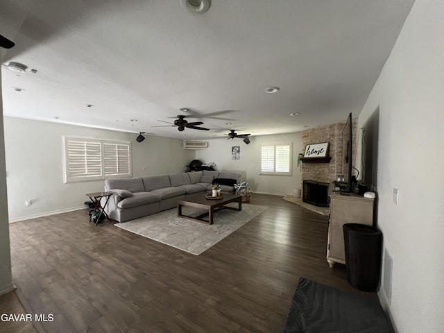6001 Brougham St, Lancaster, CA 93536 - living room with an AC wall unit, ceiling fan, dark wood-type flooring, a fireplace, and recessed lighting