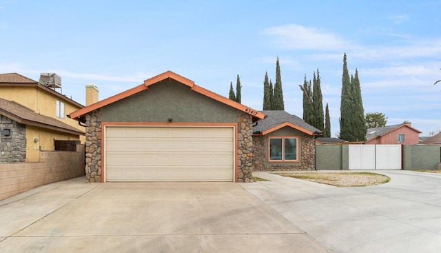 view of front of property featuring stucco siding, an attached garage, concrete driveway, and fence