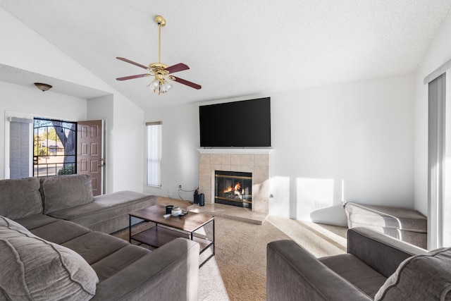 carpeted living room featuring a fireplace, a wealth of natural light, vaulted ceiling, and a textured ceiling