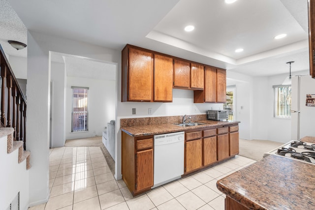 kitchen featuring hanging light fixtures, light tile patterned flooring, sink, and white appliances