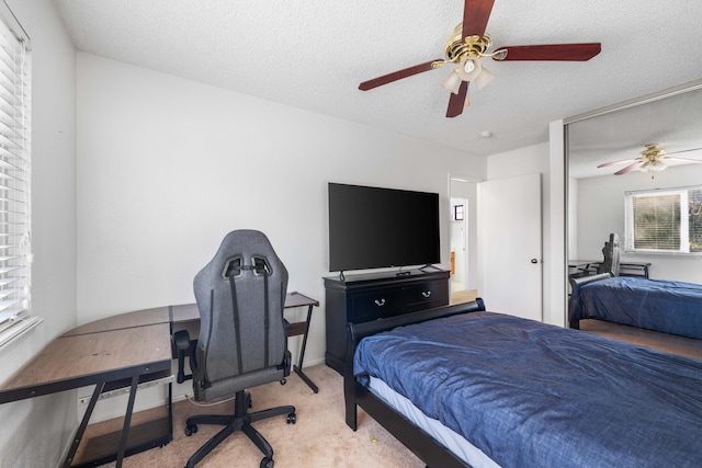 carpeted bedroom featuring a textured ceiling and ceiling fan