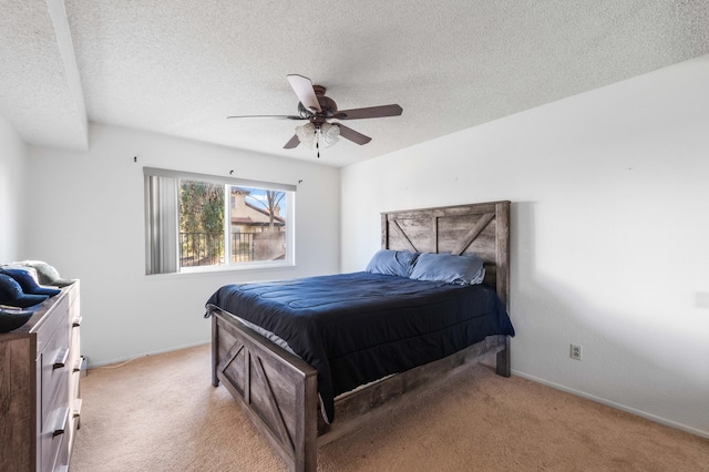 carpeted bedroom with ceiling fan and a textured ceiling