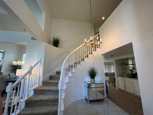 stairway with a notable chandelier and a high ceiling