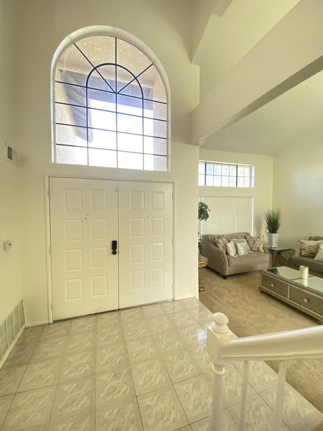 tiled foyer with a high ceiling