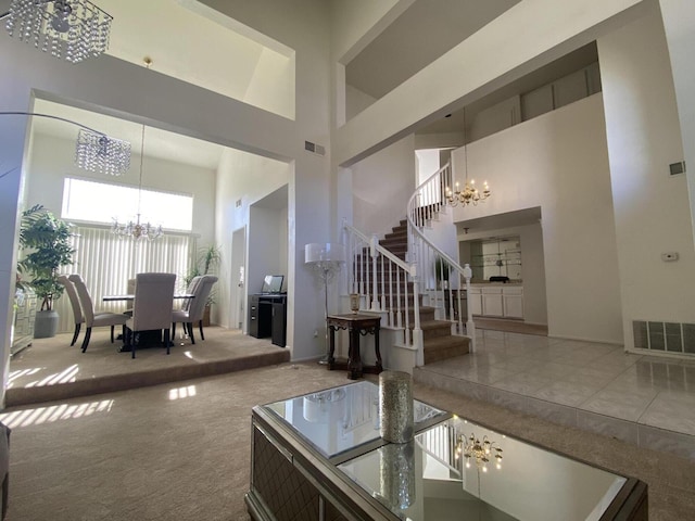 living room featuring a towering ceiling, carpet floors, and an inviting chandelier