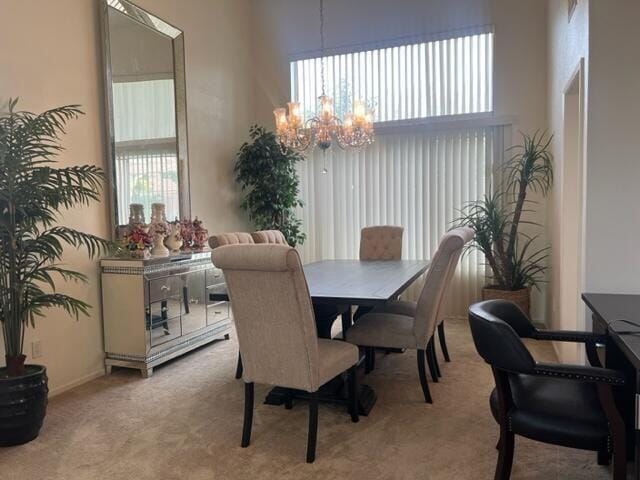 dining room with light carpet and an inviting chandelier