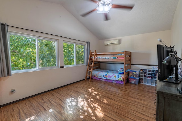 bedroom with hardwood / wood-style flooring, ceiling fan, a wall mounted air conditioner, and vaulted ceiling