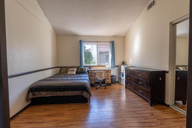 bedroom featuring hardwood / wood-style flooring and a textured ceiling