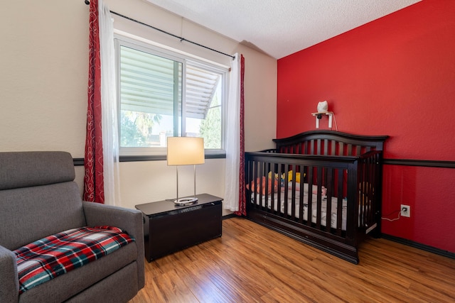 bedroom with light hardwood / wood-style floors and a textured ceiling