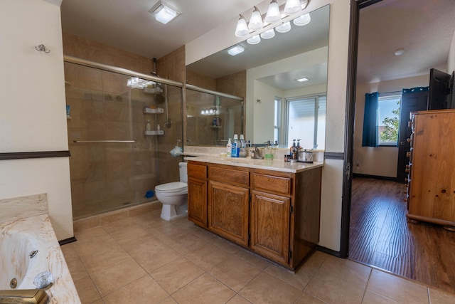 bathroom featuring toilet, vanity, a shower with door, and tile patterned flooring