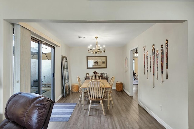 dining space featuring hardwood / wood-style floors and a notable chandelier