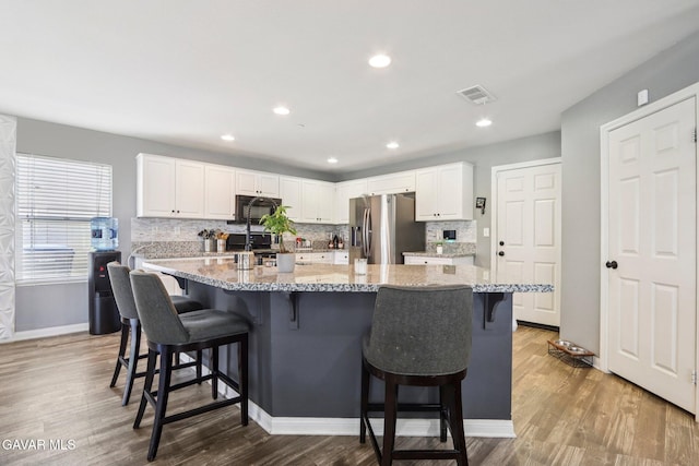 37522 Citron Pl, Palmdale, CA 93551 - kitchen featuring stainless steel fridge with ice dispenser, tasteful backsplash, white cabinets, wood finished floors, and black microwave