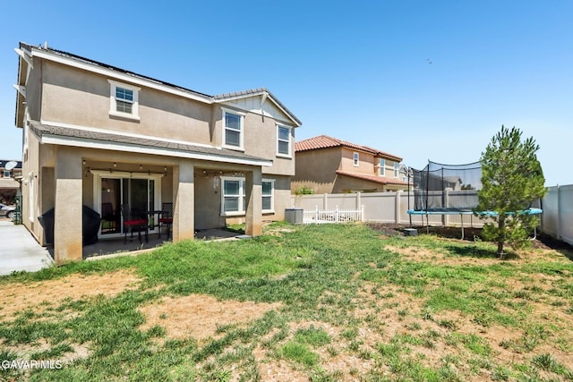 37522 Citron Pl, Palmdale, CA 93551 - back of property with stucco siding, a trampoline, a patio, and a fenced backyard