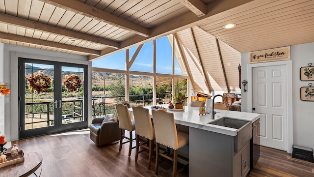 sunroom featuring beam ceiling, wooden ceiling, sink, and french doors