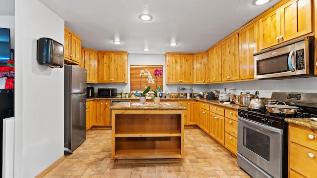 kitchen featuring appliances with stainless steel finishes, stone countertops, and a kitchen island