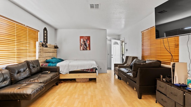 bedroom featuring light hardwood / wood-style flooring and a textured ceiling