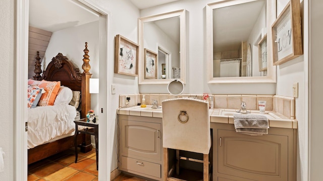 bathroom featuring tile patterned flooring, vanity, and tasteful backsplash