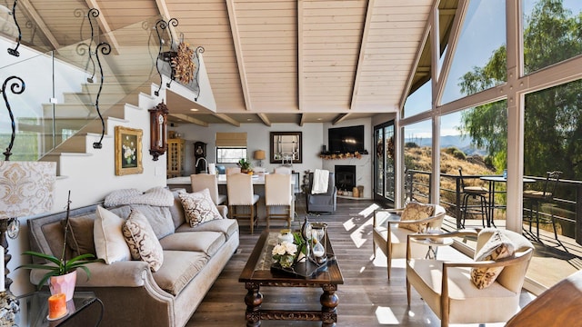 living room featuring beamed ceiling, hardwood / wood-style flooring, a healthy amount of sunlight, and wooden ceiling