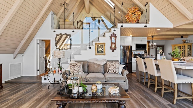 living room with wood ceiling, dark wood-type flooring, high vaulted ceiling, an inviting chandelier, and beamed ceiling