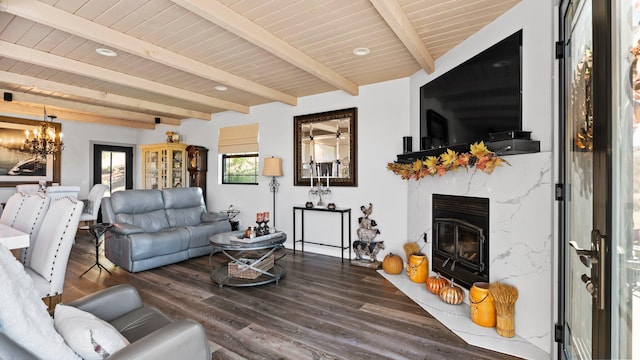 living room featuring dark wood-type flooring, a premium fireplace, beamed ceiling, a notable chandelier, and wood ceiling