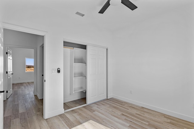 unfurnished bedroom with ceiling fan, a closet, and light hardwood / wood-style flooring