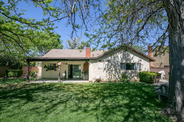 rear view of house with a chimney and a patio area