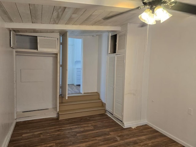 unfurnished bedroom featuring ceiling fan, wooden ceiling, dark wood-type flooring, and a closet