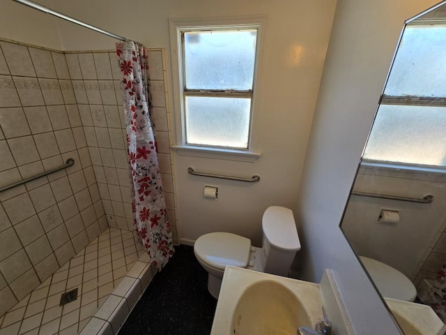 bathroom featuring a shower with curtain, toilet, and sink