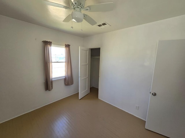 unfurnished bedroom with ceiling fan, light wood-type flooring, and a closet