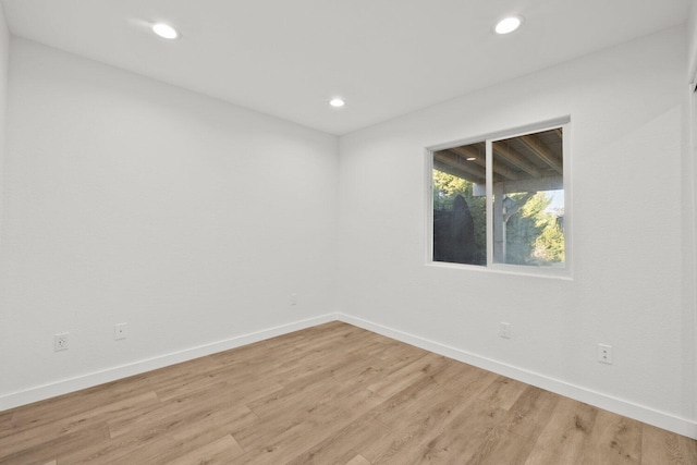 empty room featuring recessed lighting, baseboards, and light wood-style flooring