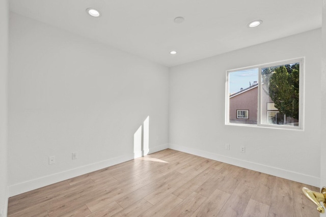 empty room with baseboards, recessed lighting, and wood finished floors