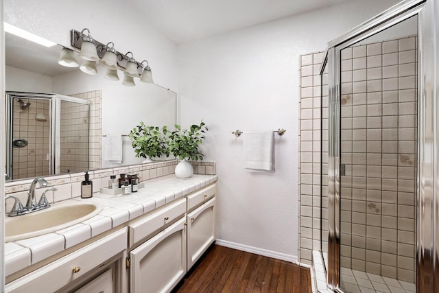 bathroom with vanity, an enclosed shower, and wood-type flooring