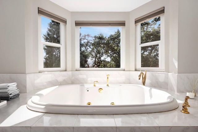 bathroom with plenty of natural light and tiled bath