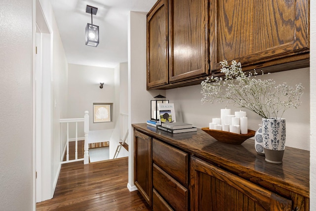 interior space with hanging light fixtures and dark wood-type flooring