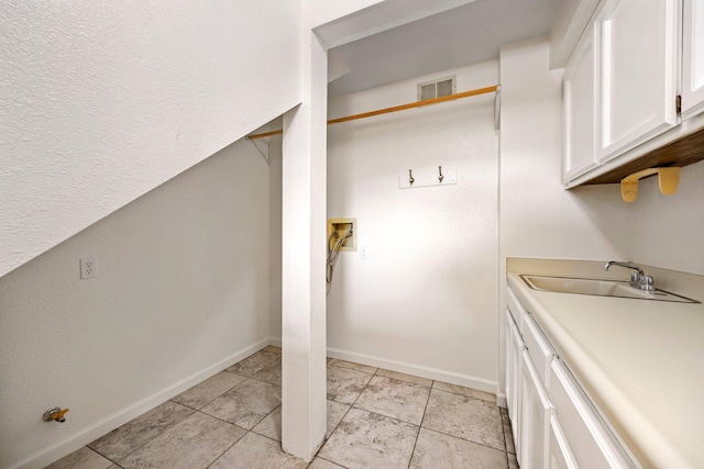 laundry area featuring light tile patterned flooring, cabinets, hookup for a washing machine, and sink