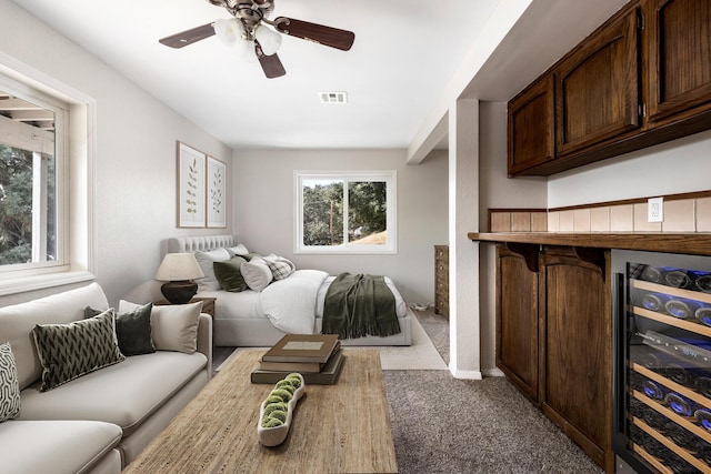 carpeted bedroom with wine cooler and ceiling fan