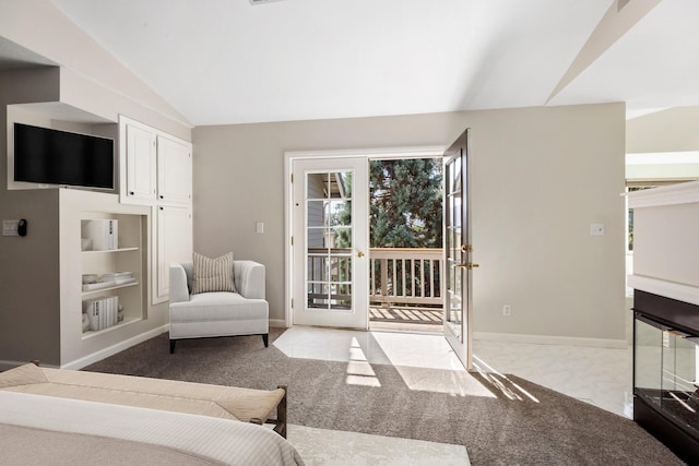 interior space featuring built in shelves, vaulted ceiling, and light colored carpet