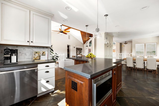 kitchen with lofted ceiling, white cabinetry, hanging light fixtures, stainless steel appliances, and tasteful backsplash