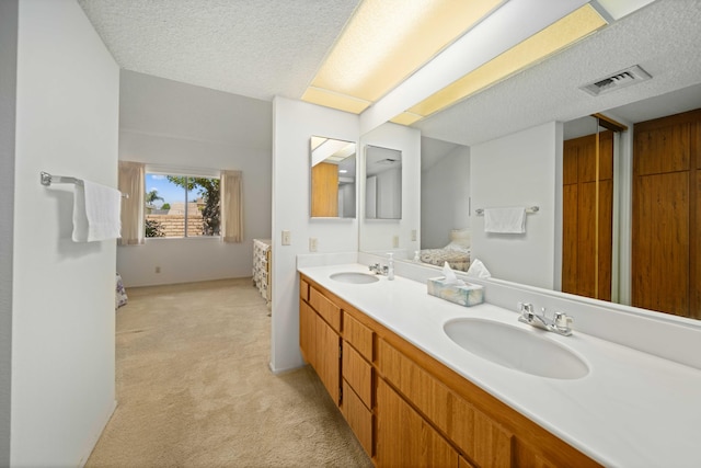 full bathroom with visible vents, a sink, and a textured ceiling