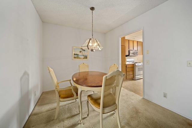 dining space with baseboards, light carpet, a textured ceiling, and a notable chandelier