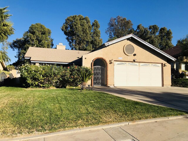 ranch-style home featuring a garage and a front lawn