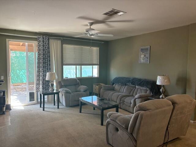 carpeted living room featuring a wealth of natural light and ceiling fan