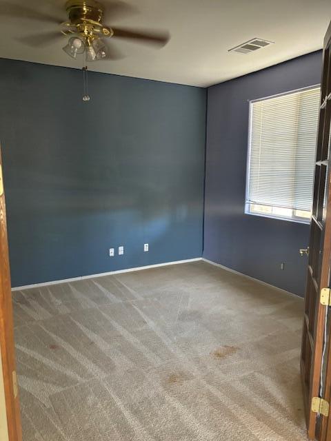 carpeted empty room featuring ceiling fan