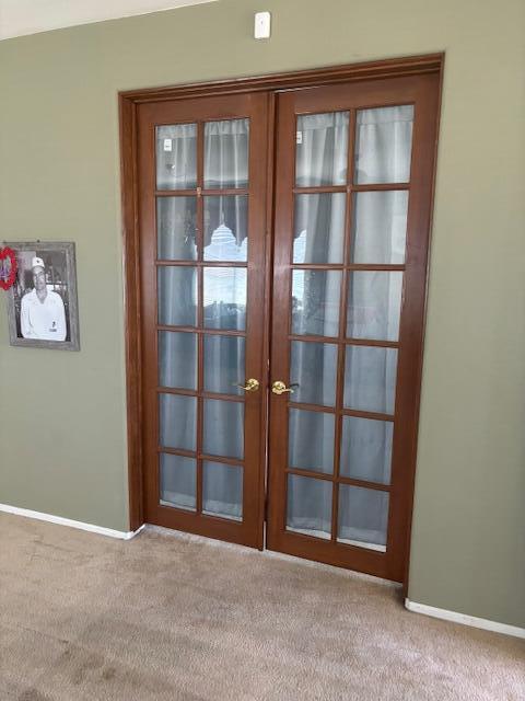 doorway featuring light carpet and french doors